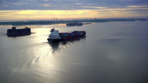 Aerial View Over Cargo Transport Ship Sailing On a Wide Lake In Summer Sunrise
