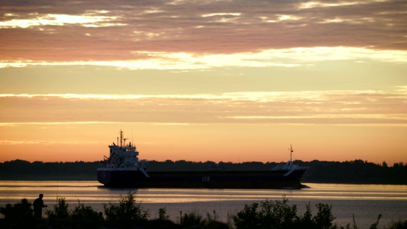 Cargo Transport Ship Sailing On a Wide River In Summer Sunrise alt