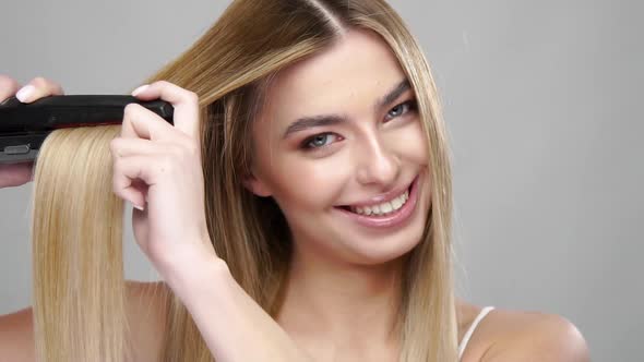 Cute Girl Straightens Hair with Professional Tool