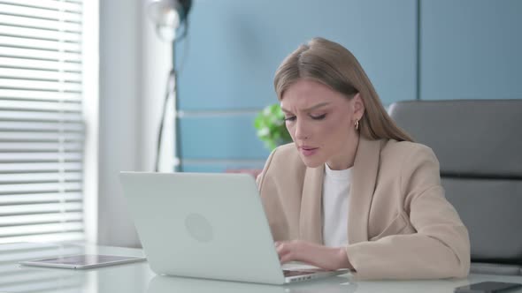 Businesswoman Reacting to Loss While Using Laptop