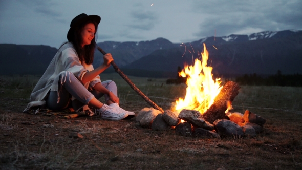 The Girl In a Warm Sweater Sitting By The Fire In The Evening.