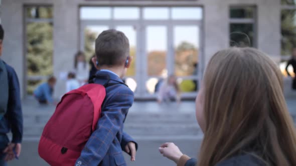 Mother Kissing Little Son Goodbye Near School