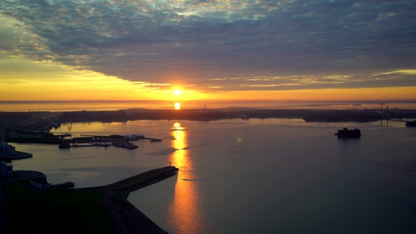 Aerial View On Sunrise Over Sea Shore, Calm Water, Ports And City