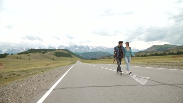 Best Friends Having Fun With Skateboard On Open Road. Young Man And Woman Longboarding Together On a