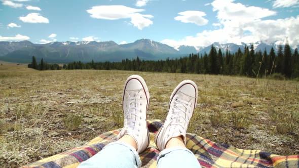 Legs of Traveler Sitting on a High Mountain 