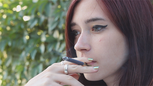Beautiful Woman Smokes a Cigarette