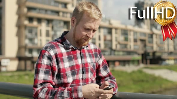 Man Writes a Message on a Smartphone