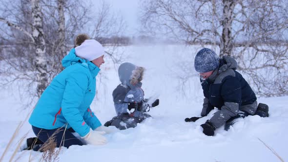 Mom and Kids Throw Snow on Each Other and Enjoy It in the Winter Park