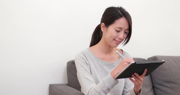 Woman drawing on tablet computer at home