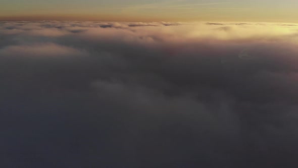 Aerial Shot Above Thick Clouds Upper Surface Against Horizon