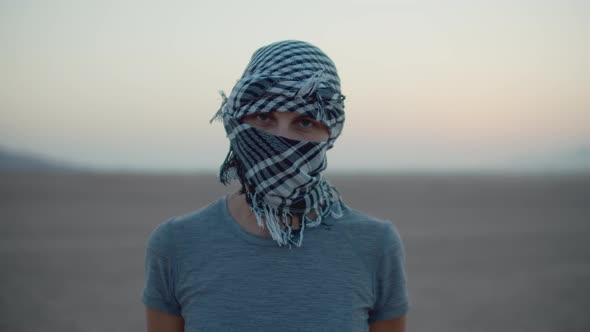Portrait of Woman Wearing Checkered Keffiyeh Standing in the Desert Looking at Camera