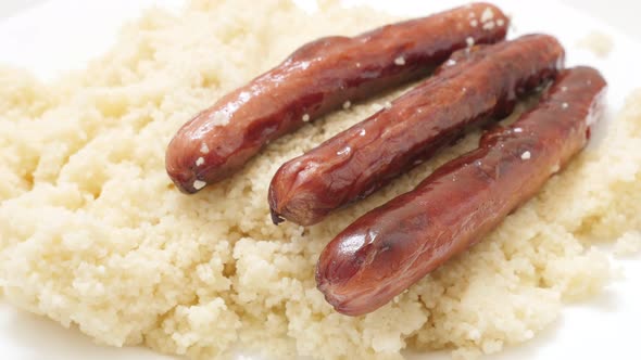 Sausages and couscous served on the plate slow tilt close-up 4K 3840X2160 30fps UHD video - Meal of 