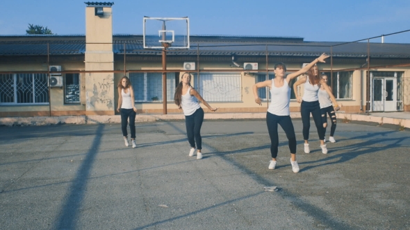 Girls in White T-shirts Dancing on the Playground in Summer