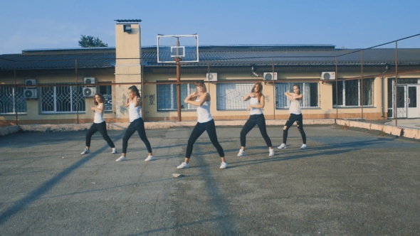 Girls In White T-shirts Dancing On The Playground In Summer