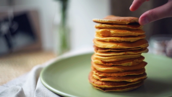 Dessert For Morning Breakfast. Man Takes Pancake From Pancake Stack