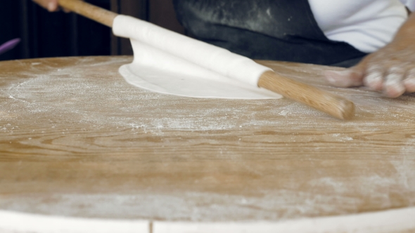 Rolling The Pastry Dough On a Flat Wooden Surface