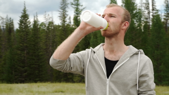 Young Muscular Build Man Drinking Water Of Bottle After Running,