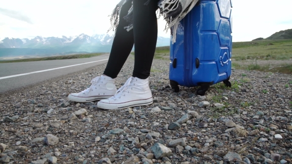 Traveler Woman Hitchhiking On a Sunny Road And Walking. Young Happy Backpacker Woman Looking For a