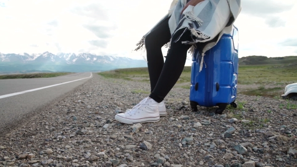 Traveler Woman Hitchhiking On a Sunny Road And Walking. Young Happy Backpacker Woman Looking For a