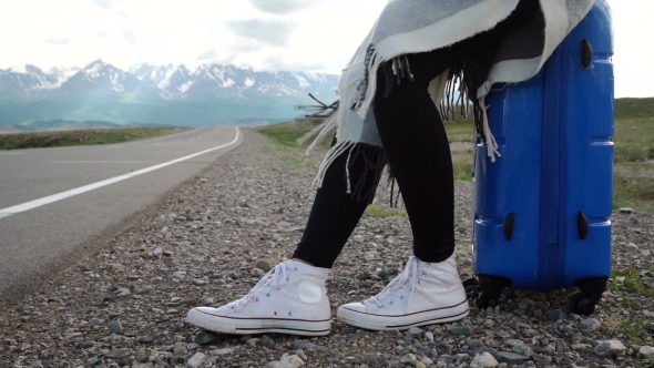 Traveler Woman Hitchhiking On a Sunny Road And Walking. Young Happy Backpacker Woman Looking For a