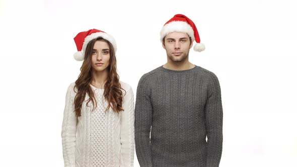  Young Couple in Sweaters Showing Present and Show Shocking Expression To Camera.