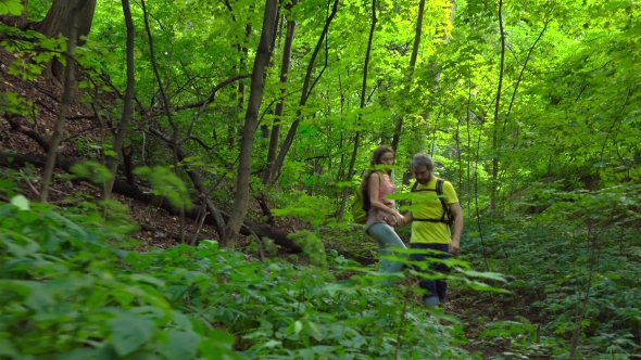 Girl And Man Hiking In Sunny Summer Forest