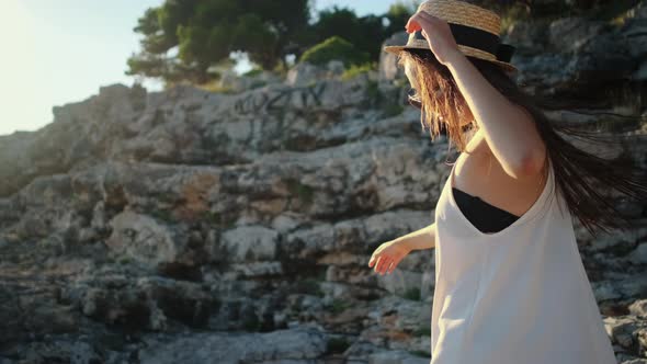 Woman is Whirling and Dancing on Rocks in Summer Day