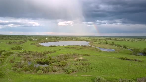 Tremendous Lake Surrounded By Green Meadows Under Clouds