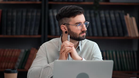 Pensive Modern Business Man Working Use Laptop Thinking Project Analyzing at Library Cabinet