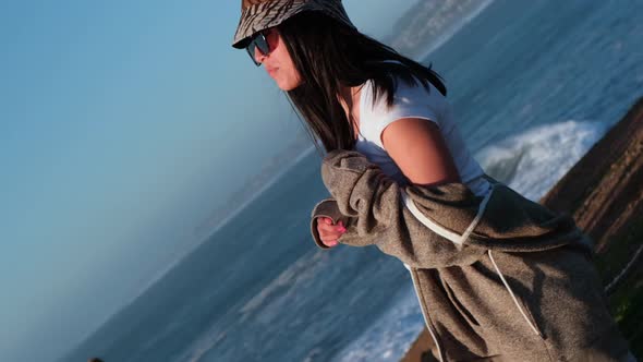 Rotating portrait of a beautiful young Latin woman in a sunset, pichilemu, chile.