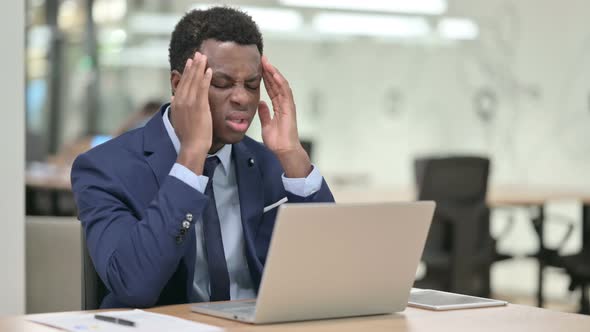 African Businessman with Headache Working on Laptop