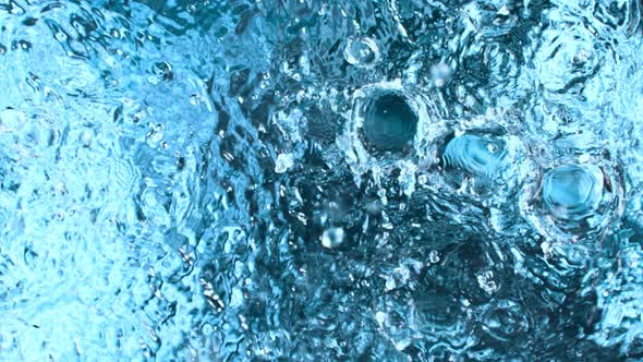 Super Slow Motion Shot of Many Water Drops Falling and Splashing on Surface at 1000Fps alt