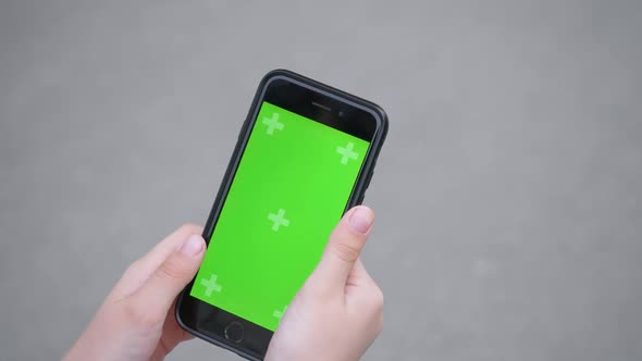 Girl Is Using a Smartphone with Green Screen, Hands