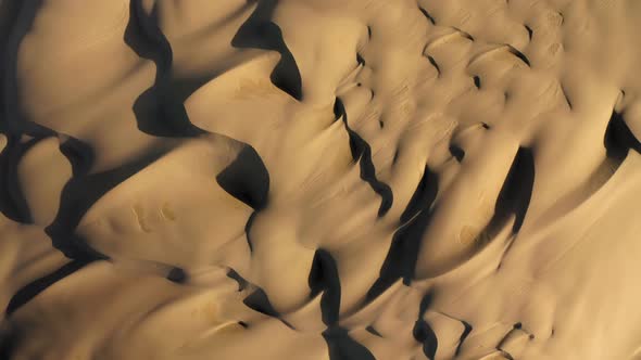  Aerial Drone View Zooming Out Massive Wavy Sand Dunes in Golden Sunset Light