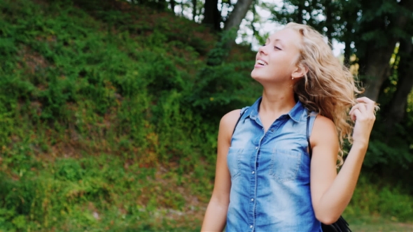 A Young Attractive Woman Walking In The Forest, Enjoying The Walk, Laugh, Straightens Hair