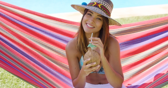 Woman With Coconut Drink And Sitting In Hammock