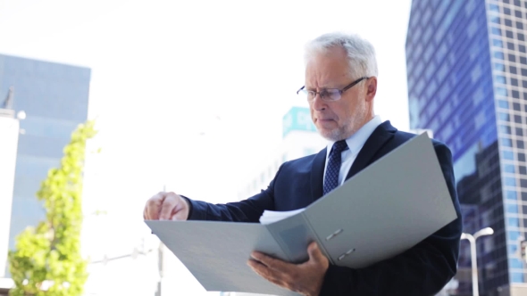 Senior Businessman With Ring Binder Folder In City