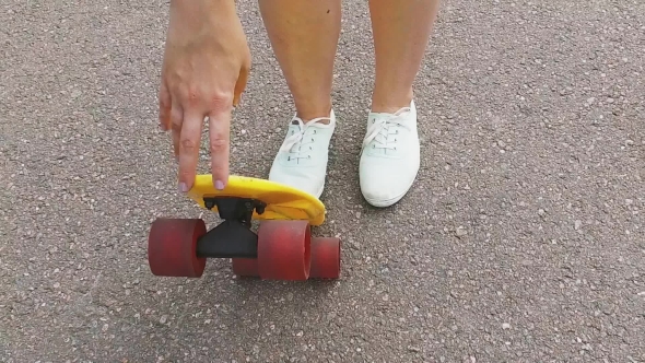 Teenage Girl Putting Short Modern Skateboard Down