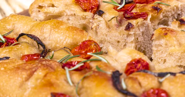 Homemade italian flat bread - Focaccia contorta. With olives, olive oil, rosemary, tomatoes. Traditi