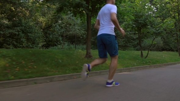 Male Runner In White Tshirt Running In The Park