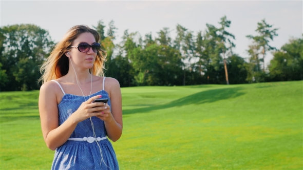 Young Woman Goes Near a Large Golf Course