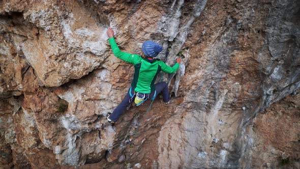 Slow Motion Aerial View Strong Female Rock Climber Climbs on Overhanging Cliff By Hard Route with