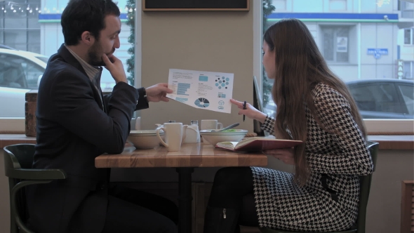 Business Man Explain Diagram To Assistant At Lunch In Cafe