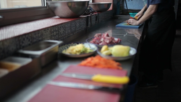 Cook Cuts The Vegetables On The Kitchen Table.