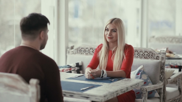 A Man And a Woman Bring a Menu In a Restaurant.