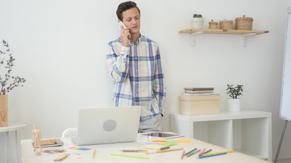 Busy Talking on Phone with Customer, Standing in Office