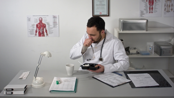 Bearded Doctor Choked During Having a Lunch At His Office. He Eating From Lunchbox Plastic Container