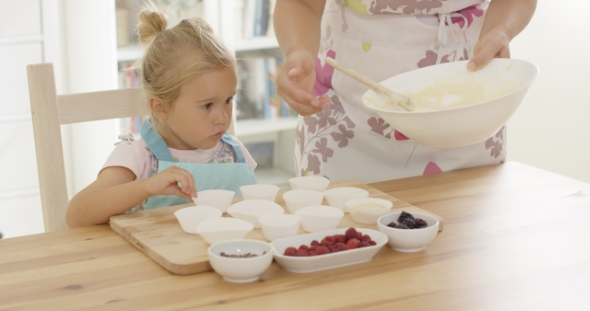 Little Girl Assisting Mum With The Baking