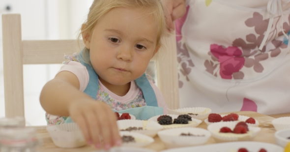 Child And Woman Preparing Muffins On Table