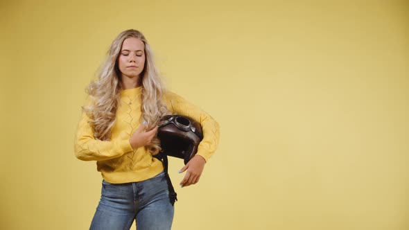 Focused Shot of a Model Turning Front To Side While Holding a Leather Helmet